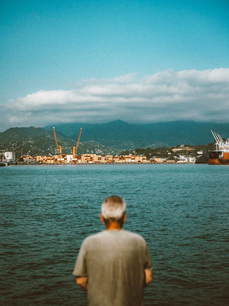 A fisher at Port Antonio harbour mends a net on the dock in early morning light